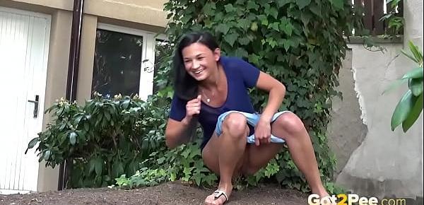  Public Pissing - Cute dark haired teen squats to pee in a garden